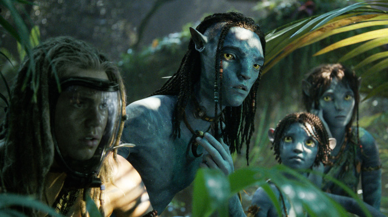 Spider, Lo'ak, Tuk, and Kiri hiding in shrubs in Avatar: Fire and Ash
