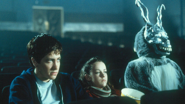 Donnie, Gretchen, and Frank sit in a movie theater in "Donnie Darko" (2001)