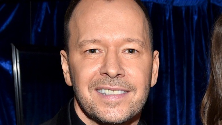 Donnie Wahlberg in front of a blue curtain