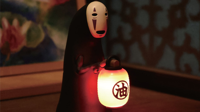 No Face holding lantern