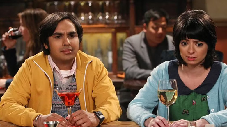 Raj and Lucy looking confused at a bar with their drinks on The Big Bang Theory