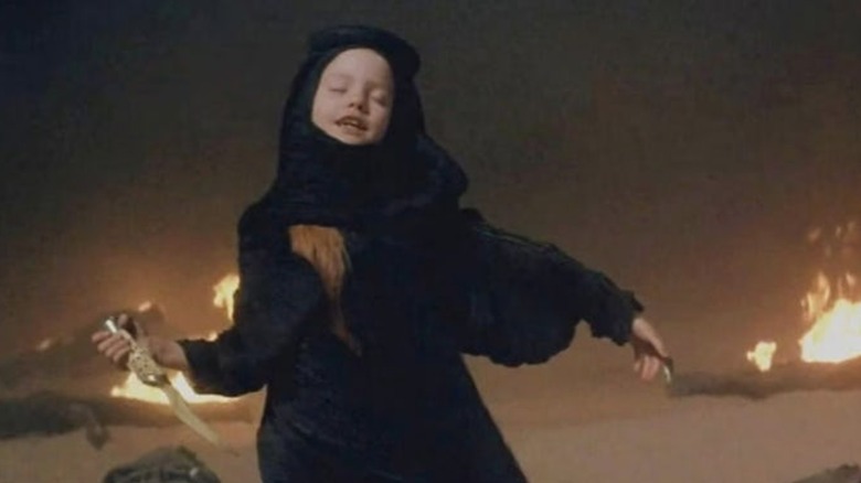 Alia holding a knife in 