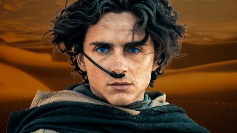 Close up of Paul Atreides against a sandy background of dunes