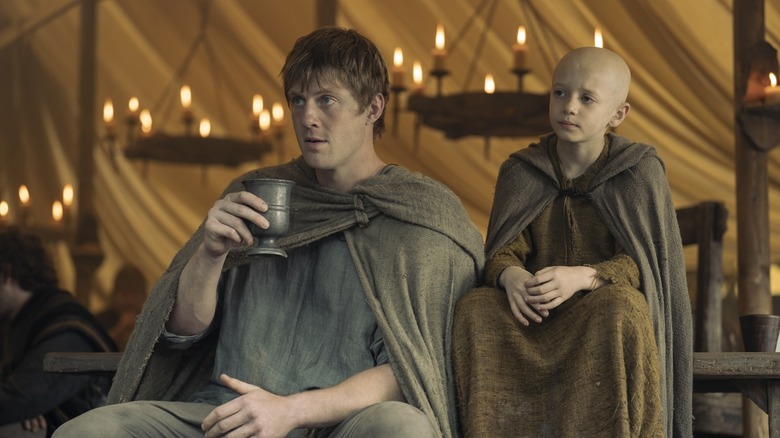 Dunk holding a cup sitting next to Egg in A Knight of the Seven Kingdoms