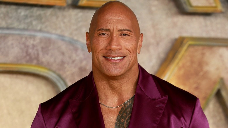 Dwayne Johnson smiling in purple suit