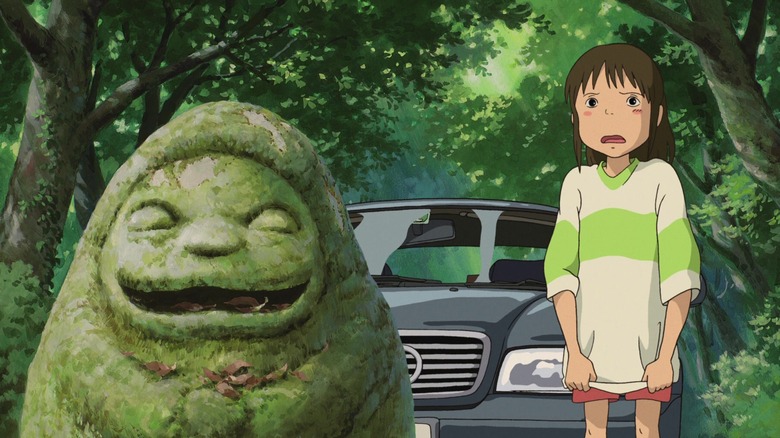 Cihiro stands next to a statue in "Spirited Away" (2001)