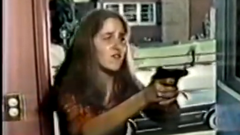 Claudia Wells holds a gun