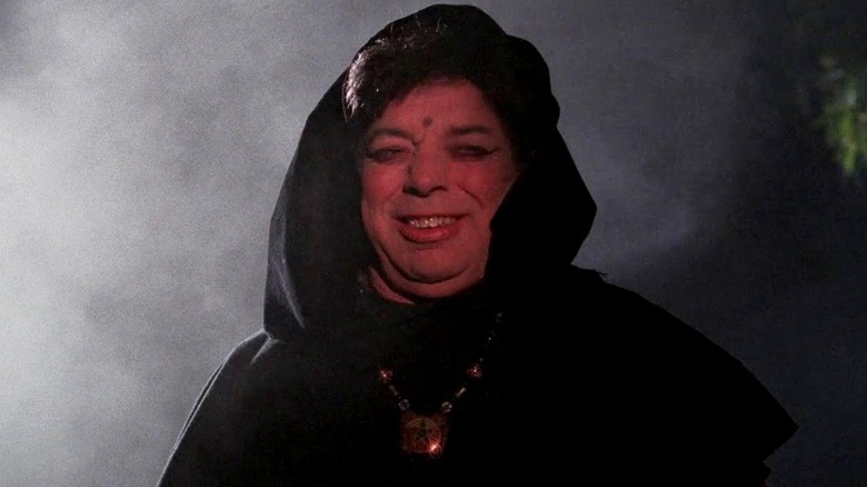 A hooded man laughs