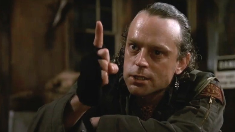 Brad Dourif holding up a finger threateningly