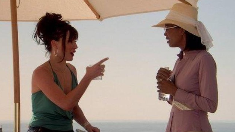 Tyler and a woman talk under an umbrella