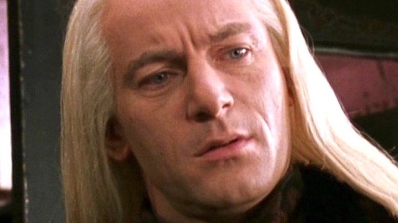 Malfoy tilts his head