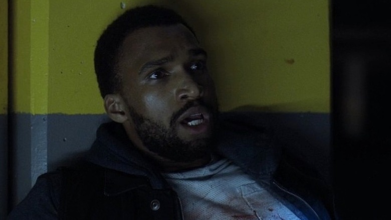 Cole leaning against a wall injured in The Marine 5: Battleground