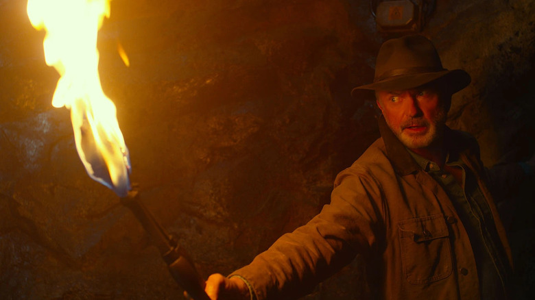 Dr. Grant lights his way through a tunnel