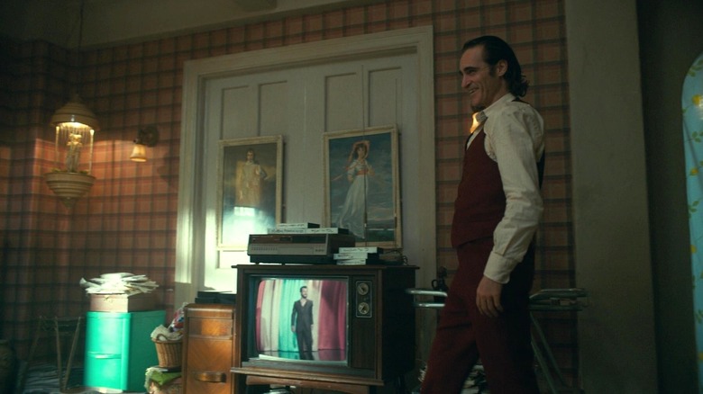 Arthur Fleck smiling and walking into the living room in "Joker" (2019)