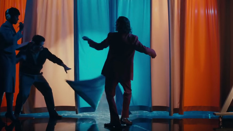 Joker comes out from behind a curtain in "Joker" (2019)