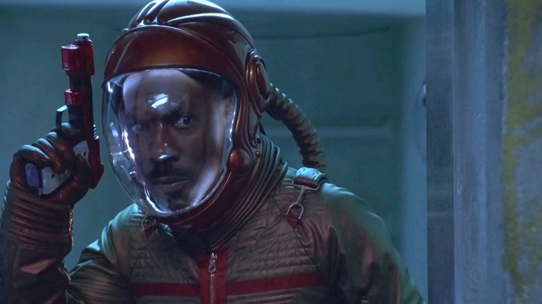 Pluto in a spacesuit holding a gun in "The Adventures of Pluto Nash" (2002)