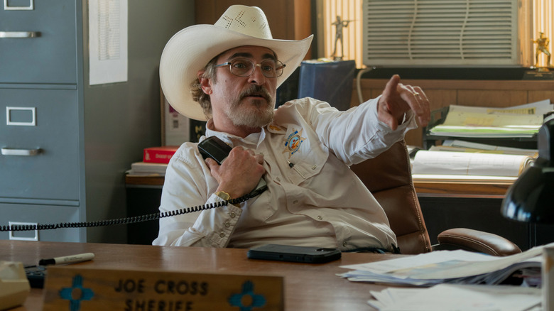 Sheriff Joe Cross holding phone and pointing with other hand