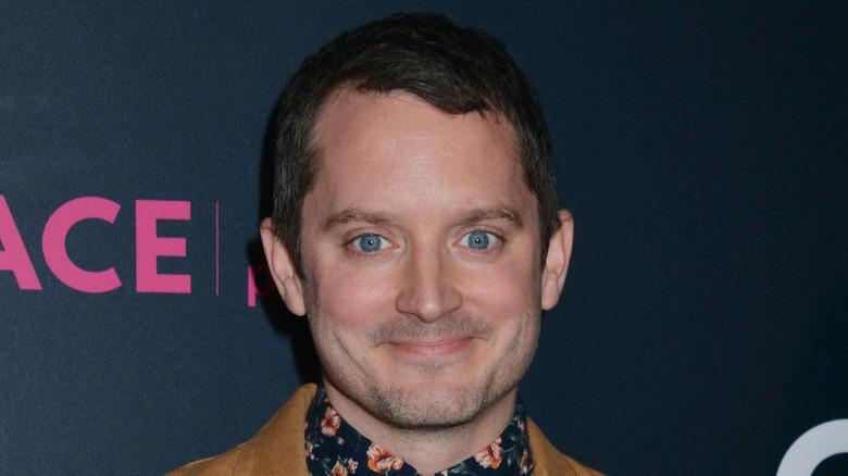 Elijah Wood smiles at event 