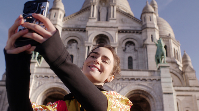 Emily taking a selfie on the steps of the Sacré-Cœur in "Emily in Paris"