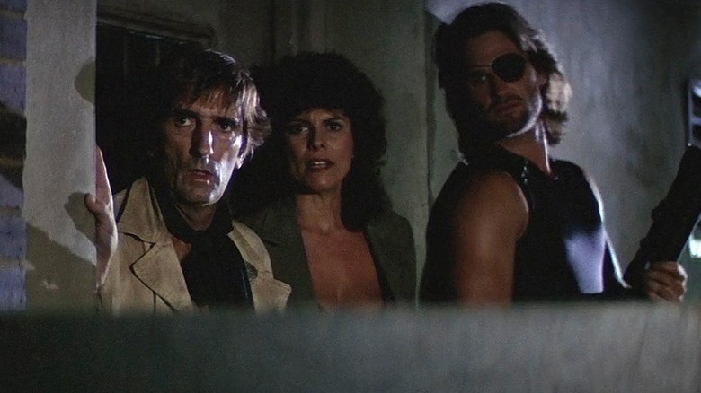 Brain, Maggie, and Snake hiding behind wall