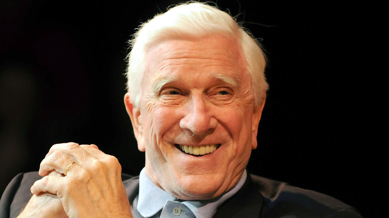 Leslie Nielsen smiling in dark blazer