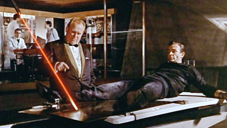 James Bond on the table as Goldfinger explains the laser in "Goldfinger" (1964)