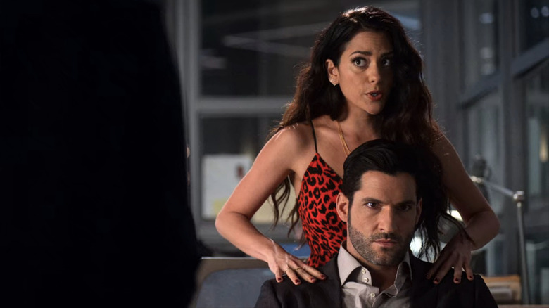 Eve rubbing Lucifer's shoulders
