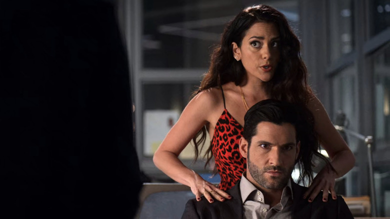 Eve rubbing Lucifer's shoulders