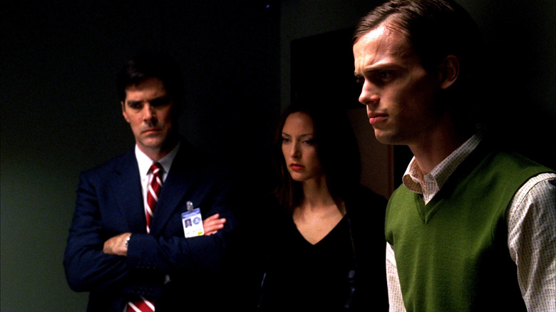 Hotch, Elle, and Reid standing in dark room Criminal Minds