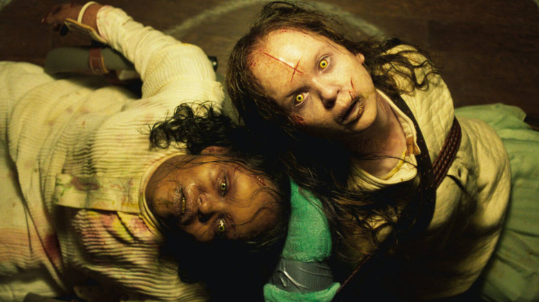 Kat and Angela possessed by a demon, tied to chairs back to back in The Exorcist: Believer