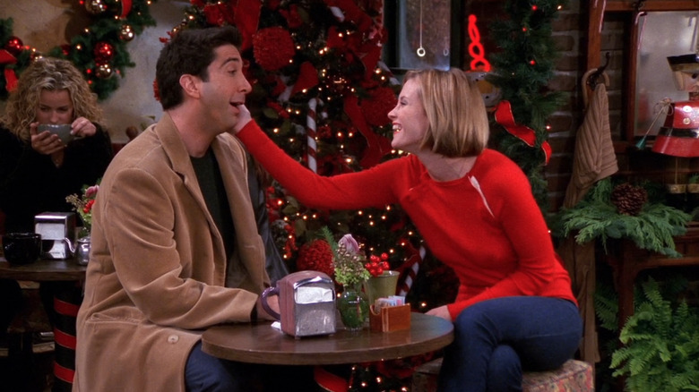 Mona holds Ross' cheek smiling
