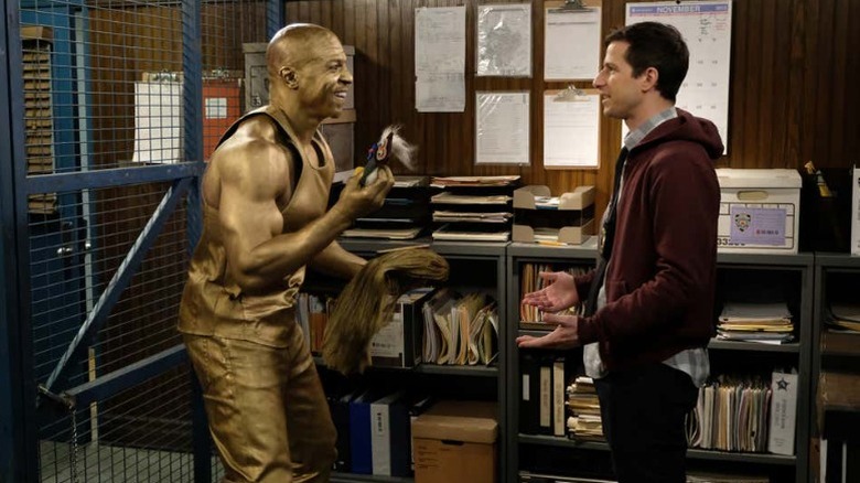 A gold-painted Terry Jeffords talks exictedly with Jake Peralta