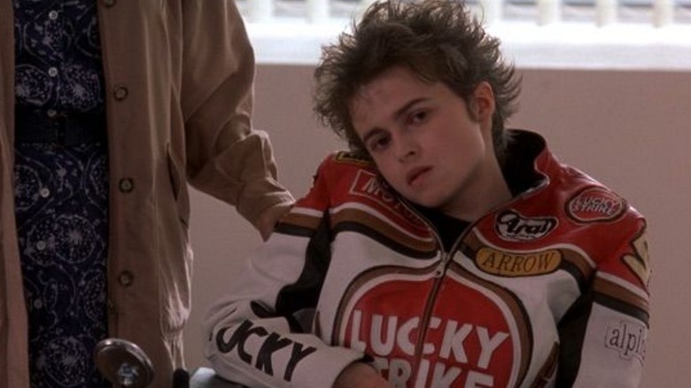 Jane in a wheelchair wearing a jacket that reads "Lucky Strike"