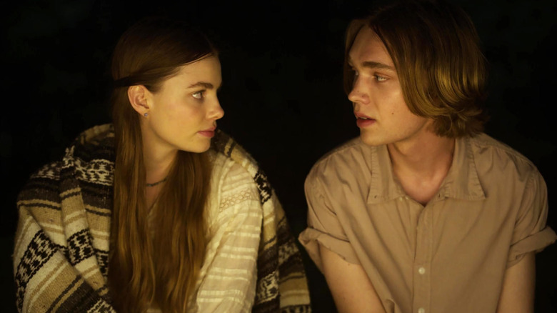 Alaska and Pudge looking at one another by firelight in "Looking for Alaska" (2019)