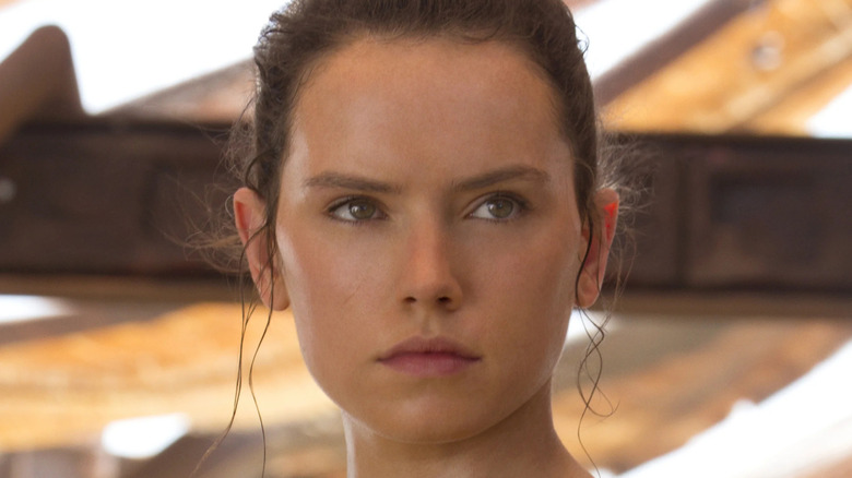 Rey holds a lightsaber