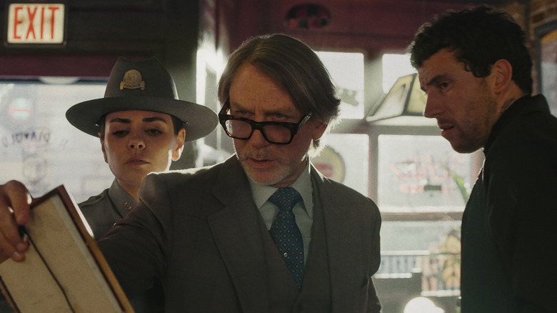 Chief Scott, Benoit Blanc, and Father Jud examine a clue in "Wake Up Dead Man" (2025)