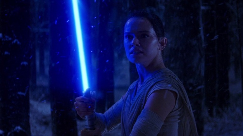 Rey with the lightsaber for the first time