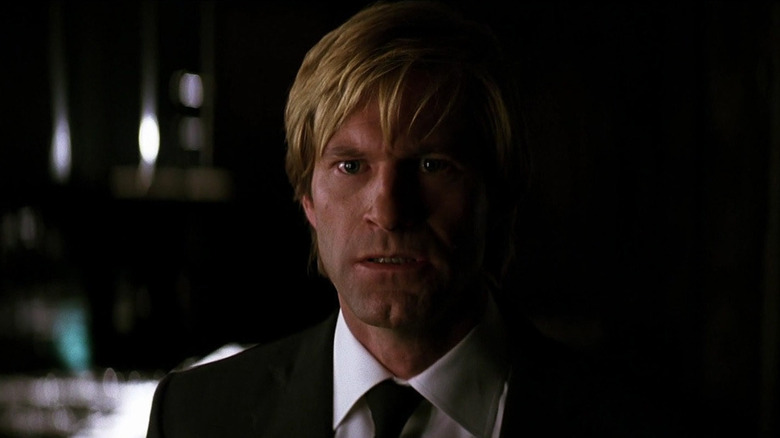 Aaron Eckhart lying in a hospital bed