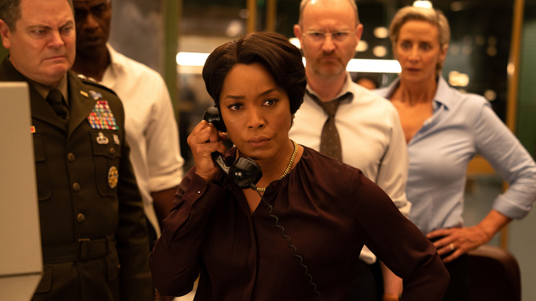 Sydney and agents in the background as Erika is listening to phone