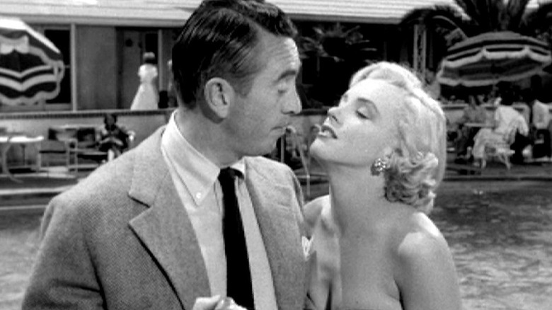 Monroe standing close to man at pool 