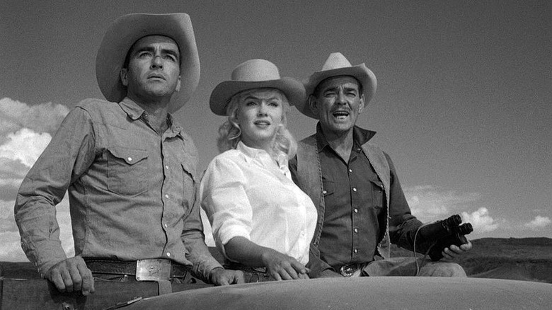 Monroe standing next to Gable and Clift wearing cowboy hats