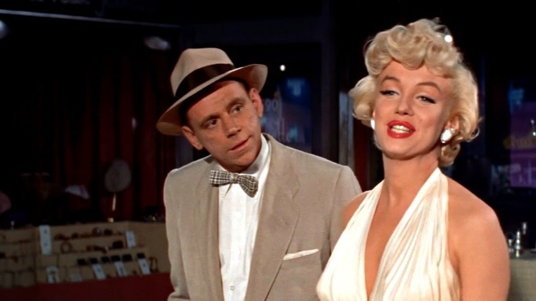 Monroe in cream dress standing next to Ewell