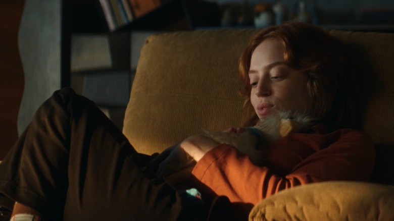 Nibs snuggling a stuffed animal and discussing her self-proclaimed immaculate conception with Dame Sylvia (off-screen)