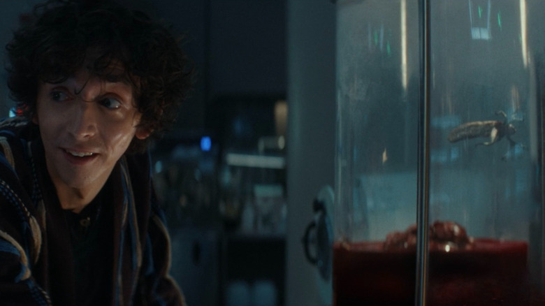 Boy Kavalier looking away from the blood-soaked ticks contained in his lab