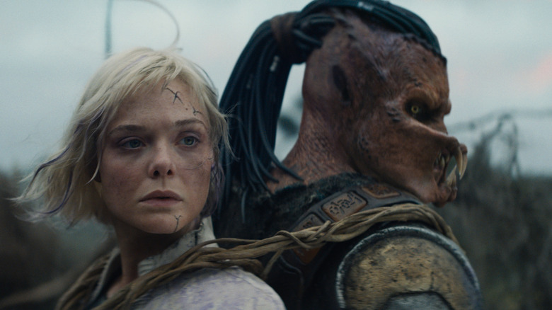 Thia strapped to Dek's back in Predator: Badlands