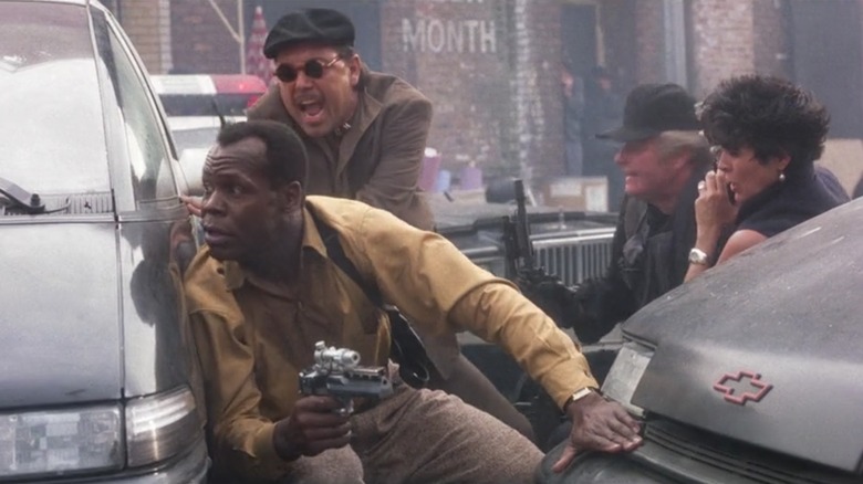 Harrigan hides behind a car in a firefight in Predator 2