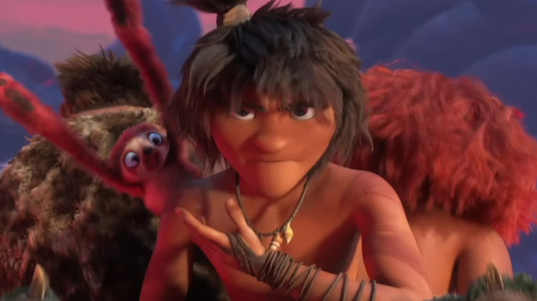 A prehistoric man gestures at an animal over his shoulder