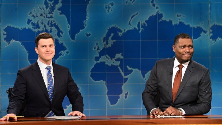 Micheal Che and Colin Jost smile on Weekend Update