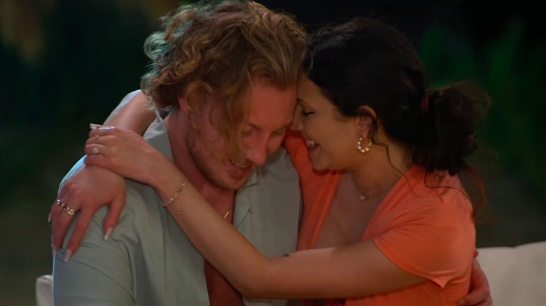 Johnny and Amy embracing while sitting on a couch in "Love Is Blind."