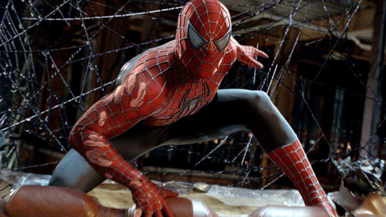 Injured Spider-Man posing in front of webs